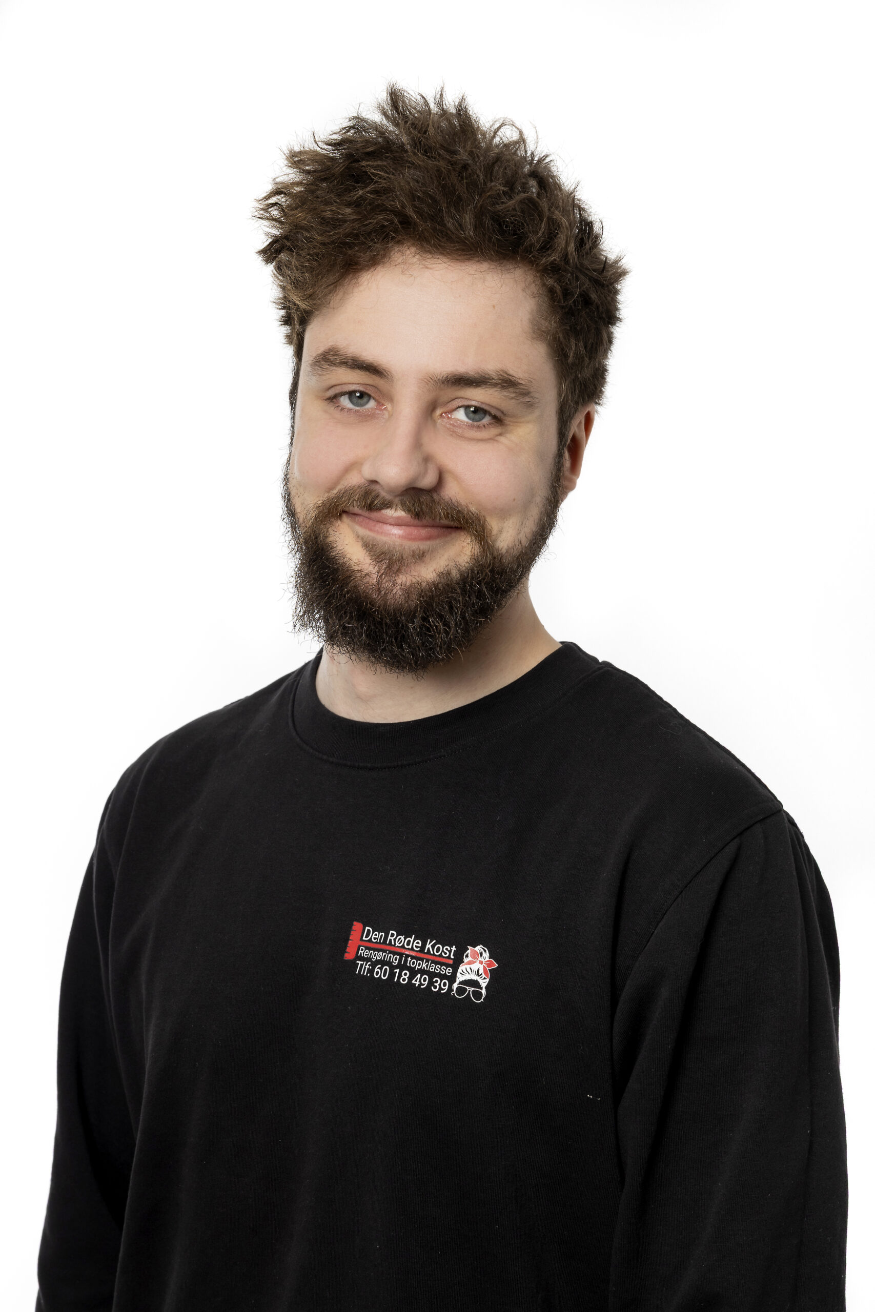 Smilende mand med skæg i sort T-shirt